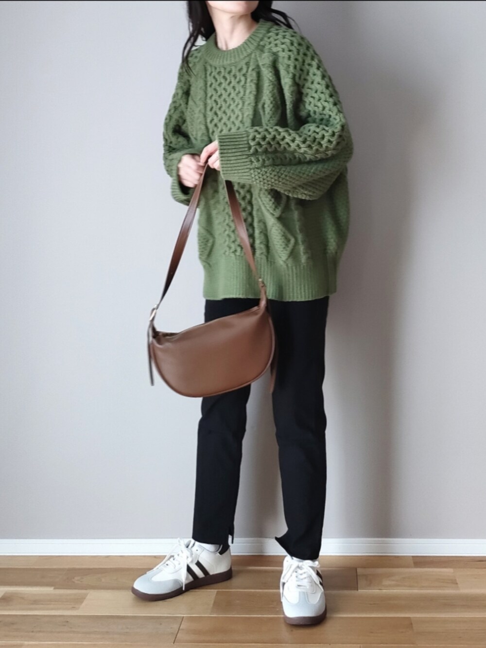 グリーン系のニット/セーター、ブラウン系のショルダーバッグ、グレー系のスニーカーを着用したレディースの秋コーディネートの4枚目の写真