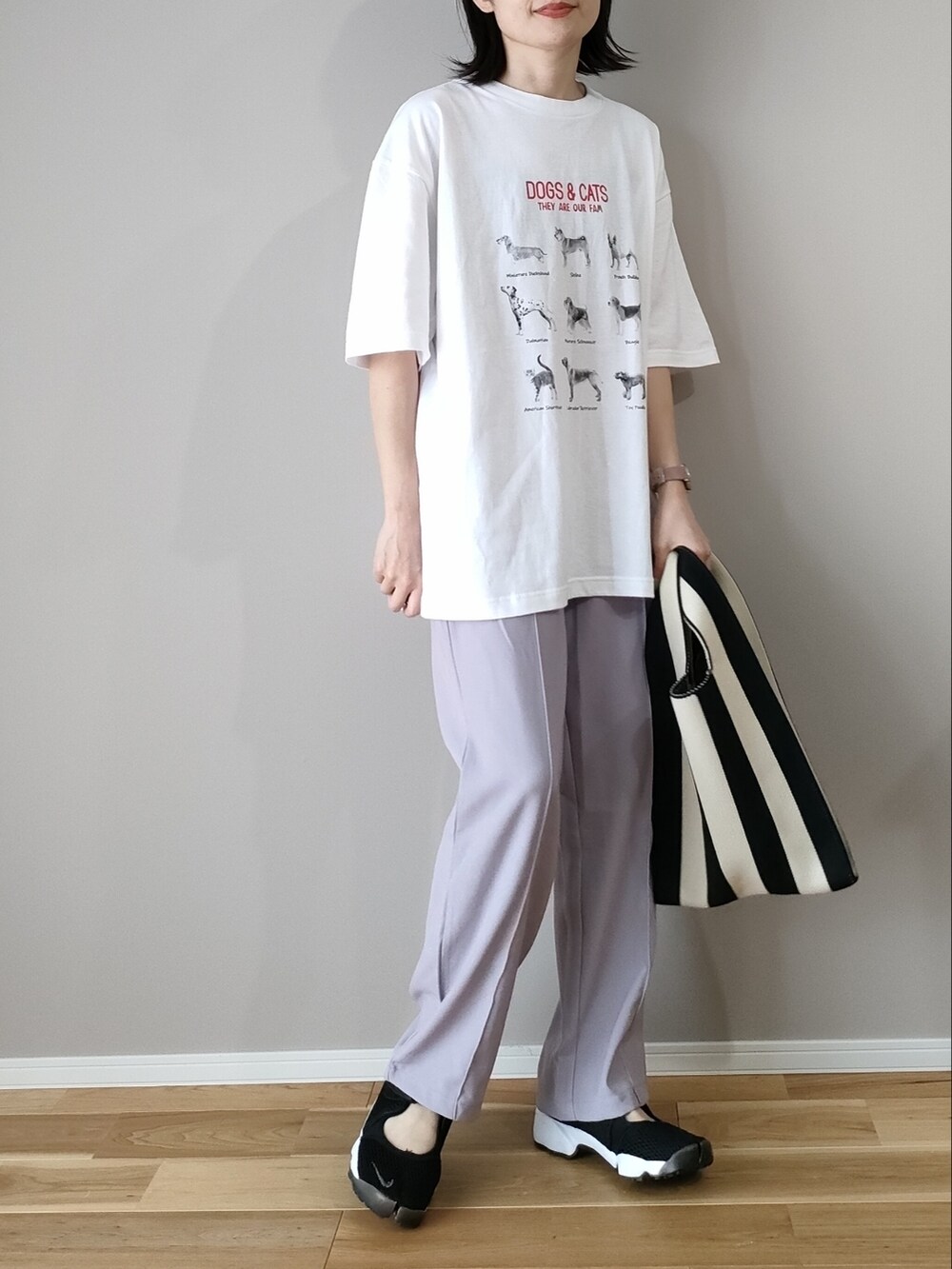 ホワイト系のTシャツ/カットソー、ブラック系のショルダーバッグ、ブラック系のスニーカーを着用したレディースの春コーディネートの3枚目の写真