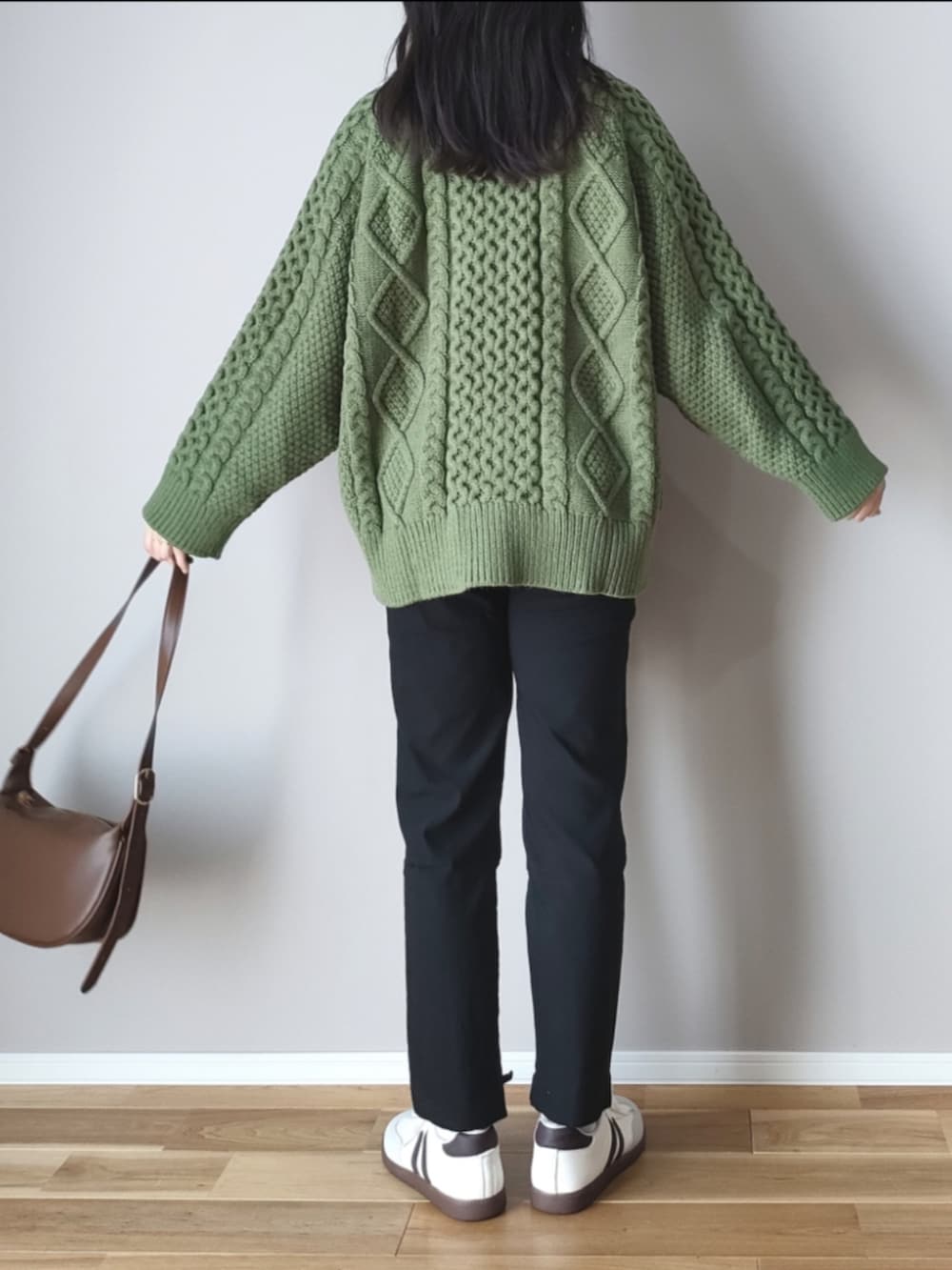 グリーン系のニット/セーター、ブラウン系のショルダーバッグ、グレー系のスニーカーを着用したレディースの秋コーディネートの5枚目の写真