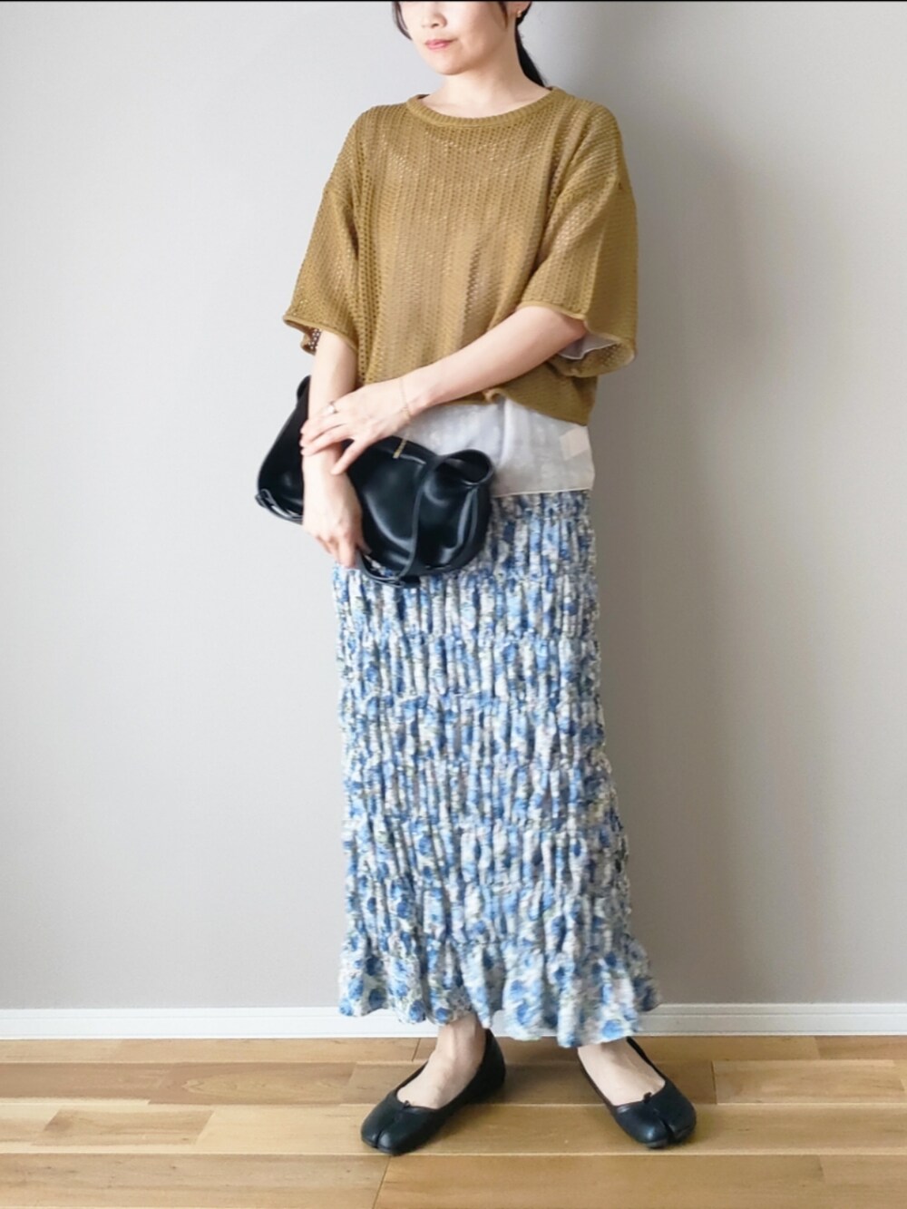 グリーン系のニット/セーター、ホワイト系のシャツ/ブラウス、ブルー系のスカートを着用したレディースの夏コーディネートの2枚目の写真