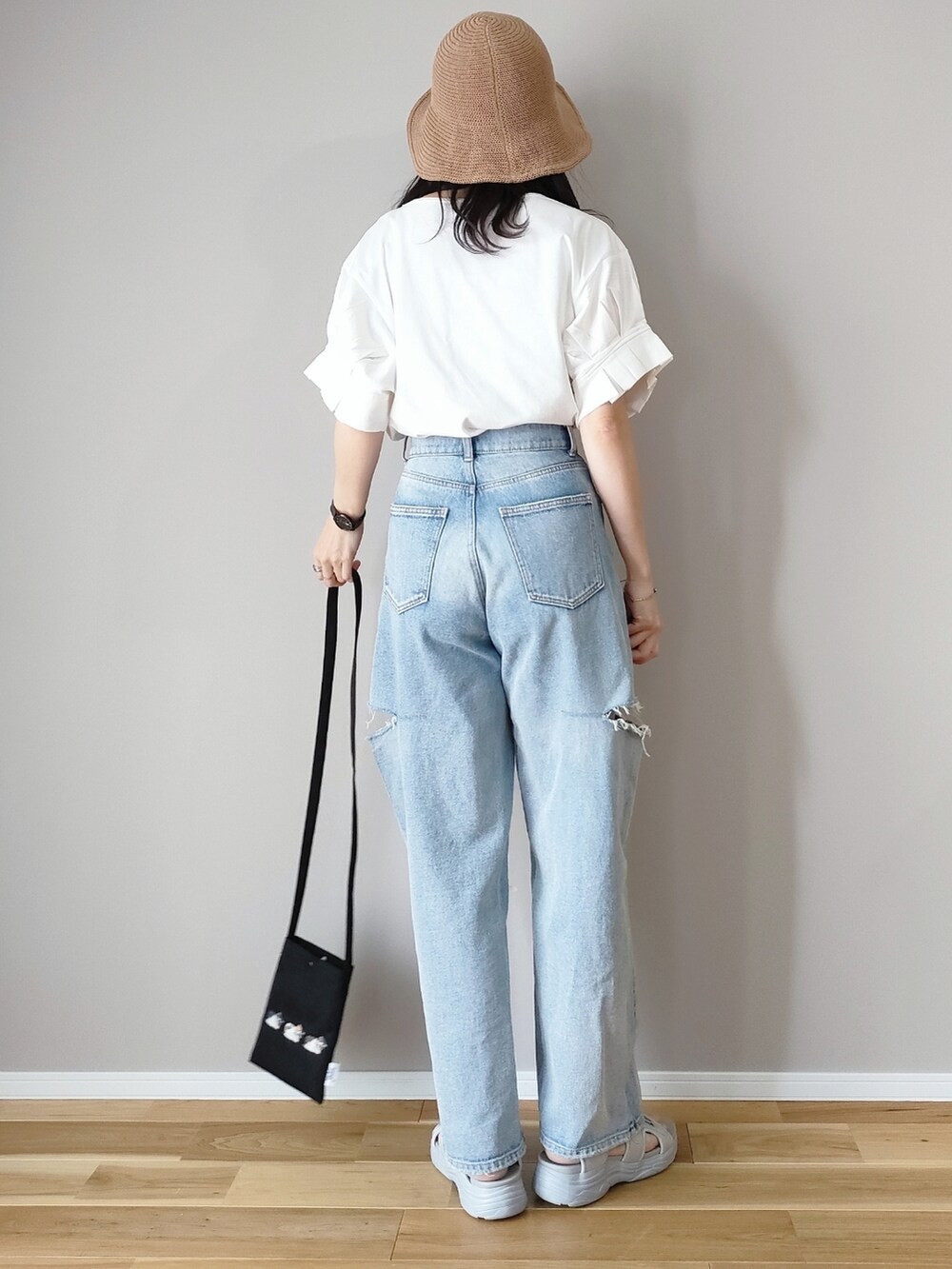 ホワイト系のTシャツ/カットソー、グレー系のサンダル、ブルー系のデニムパンツを着用したレディースの春コーディネートの4枚目の写真