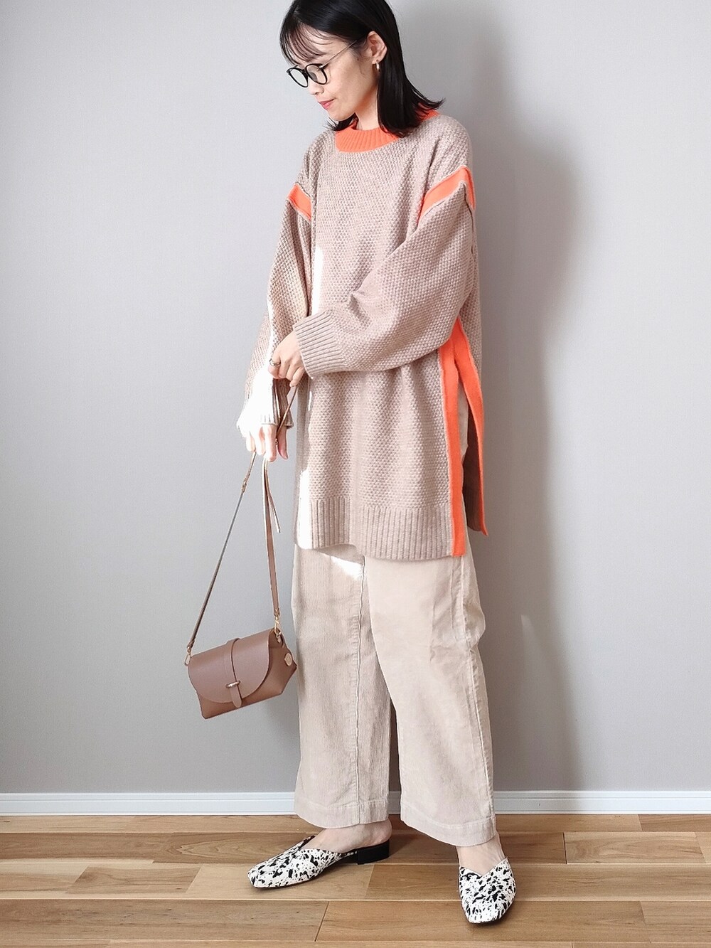 ベージュ系のニット/セーター、ホワイト系のサンダル、イエロー系のショルダーバッグを着用したレディースの冬コーディネートの2枚目の写真