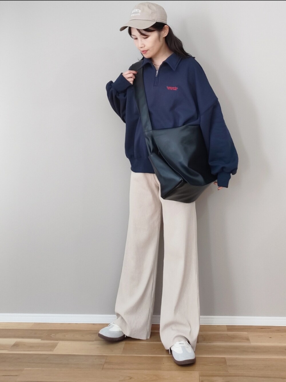 ブルー系のスウェット、ブラック系のショルダーバッグ、グレー系のスニーカーを着用したレディースの冬コーディネートの2枚目の写真