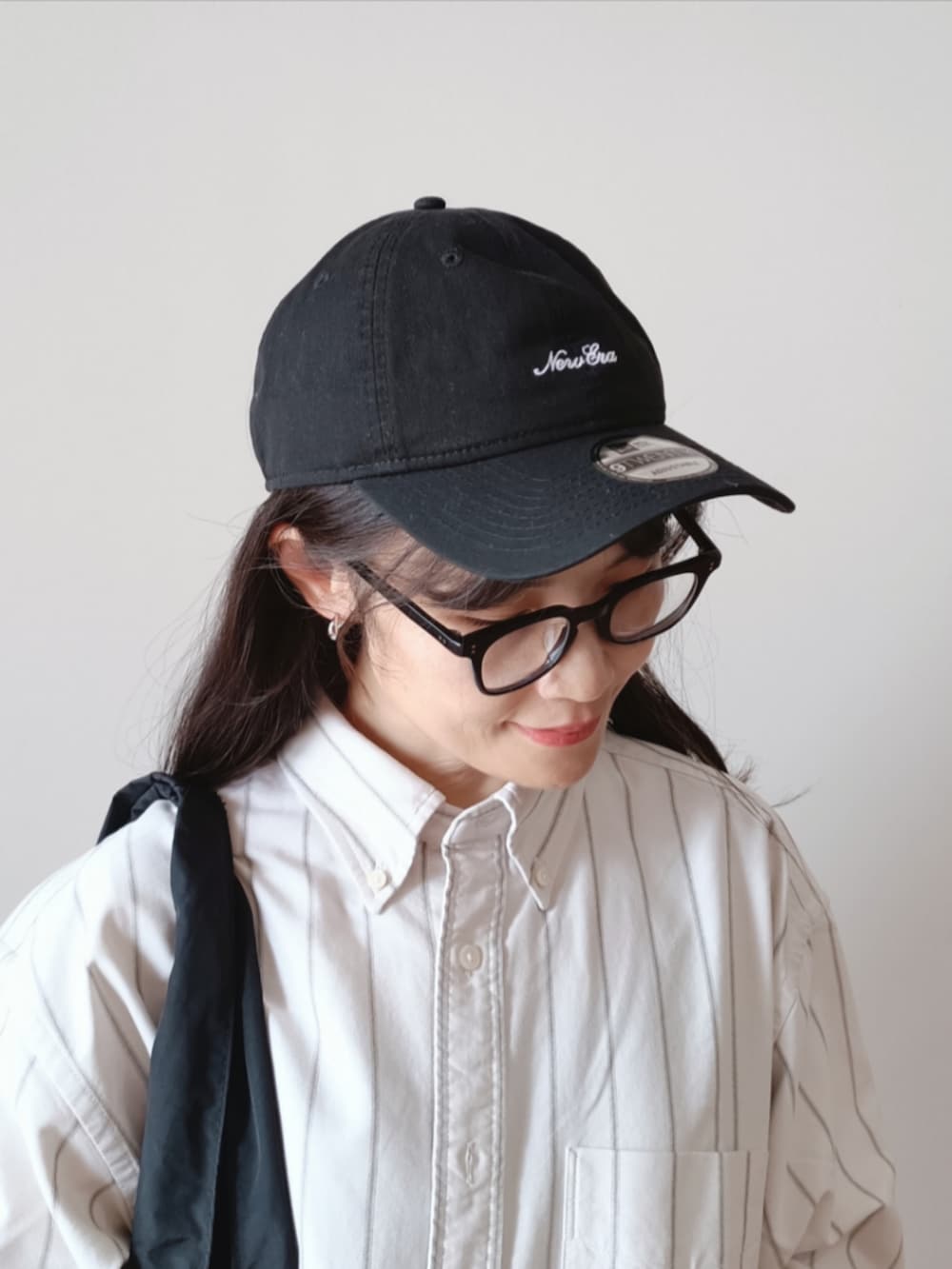 ブラック系のトートバッグ、ベージュ系のシャツ/ブラウス、ホワイト系のカーゴパンツを着用したレディースの秋コーディネートの2枚目の写真