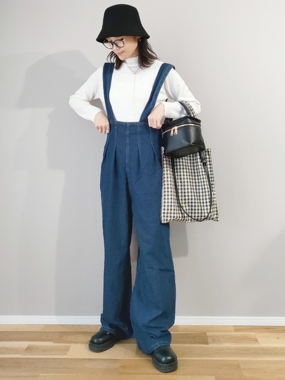 ブルー系のサロペット/オーバーオール、ホワイト系のニット/セーター、ベージュ系のトートバッグを着用したレディースの冬コーディネートの3枚目の写真
