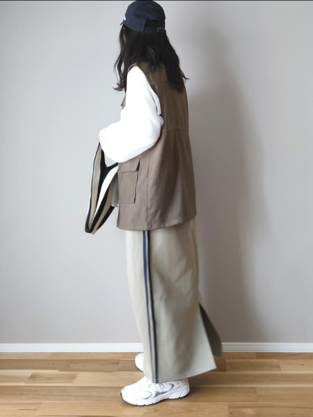 ホワイト系のシャツ/ブラウス、グリーン系のベスト、ブルー系のスカートを着用したレディースの秋コーディネートの5枚目の写真