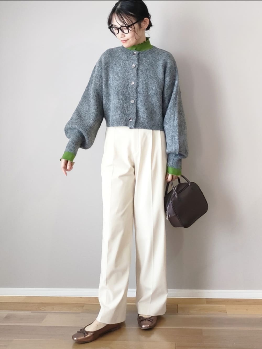 グレー系のカーディガン/ボレロ、グリーン系のTシャツ/カットソー、ブラウン系のボストンバッグを着用したレディースの秋コーディネートの2枚目の写真