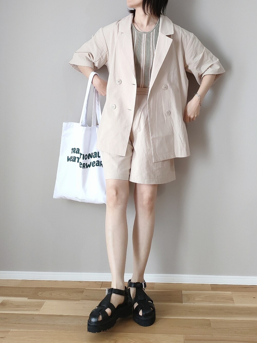 ベージュ系のテーラードジャケット、ベージュ系のその他パンツ、ホワイト系のトートバッグを着用したレディースの春コーディネートの2枚目の写真