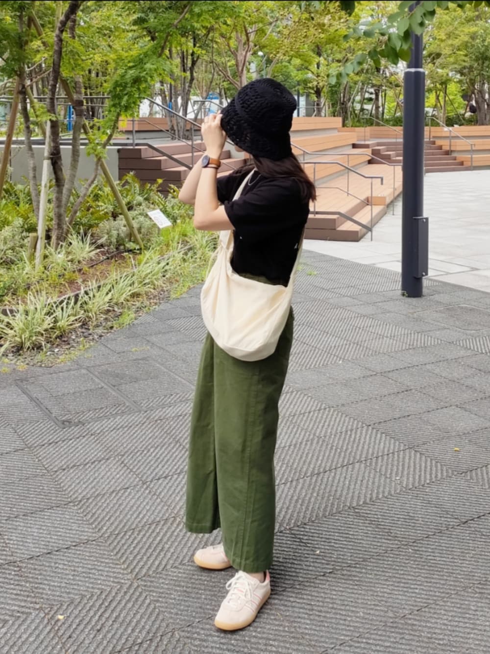 ベージュ系のスニーカー、ブラック系のTシャツ/カットソー、グリーン系のスカートを着用したレディースの秋コーディネートの2枚目の写真