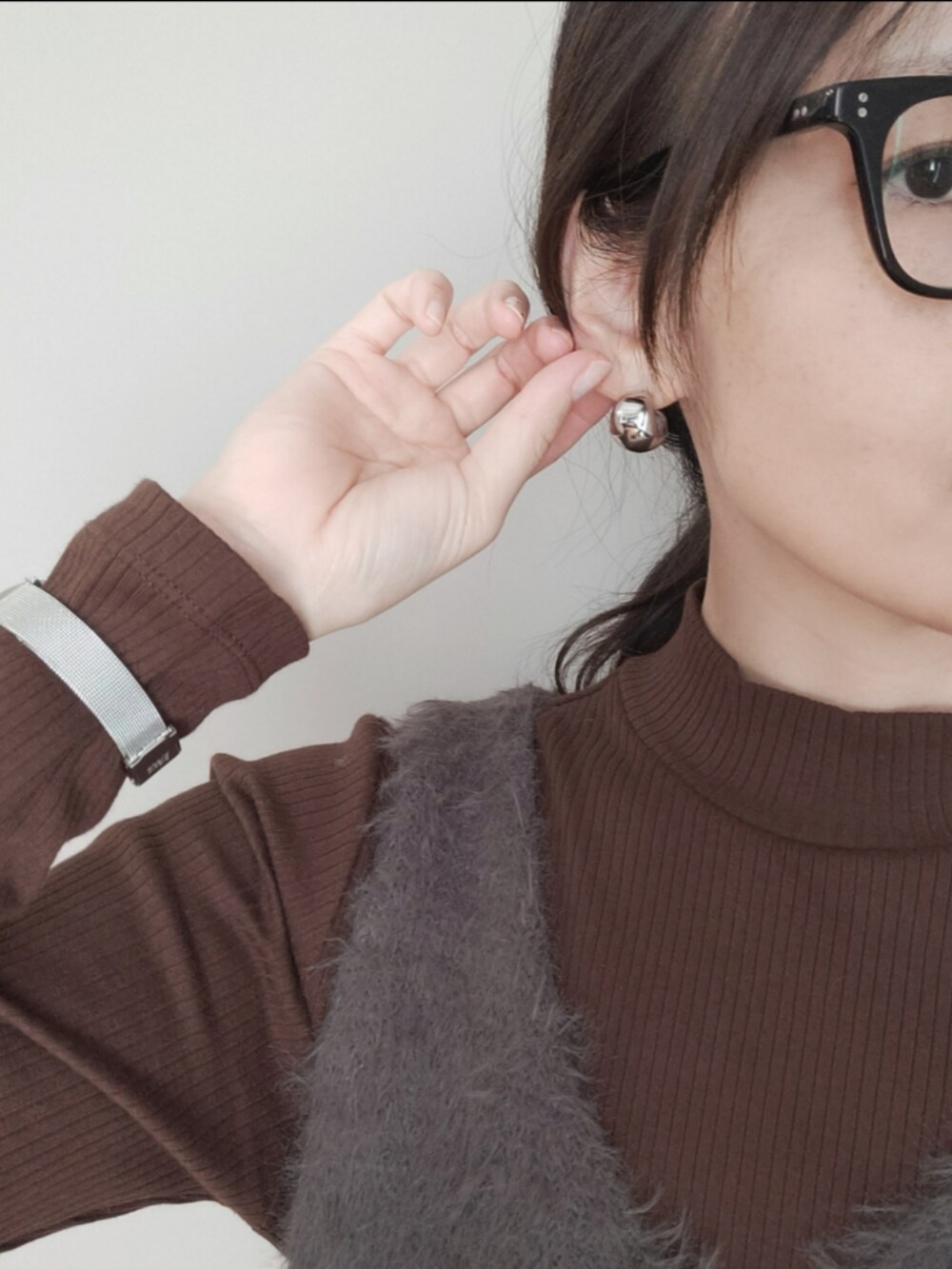 ブラック系のスカート、グレー系のベスト、ブラック系のブーツを着用したレディースの冬コーディネートの4枚目の写真