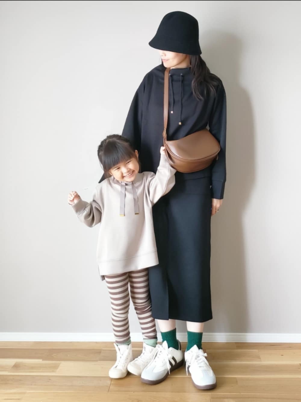 ベージュ系のスウェット、ブラック系のスウェット、ブラック系のスカートを着用したレディースの秋コーディネートの2枚目の写真