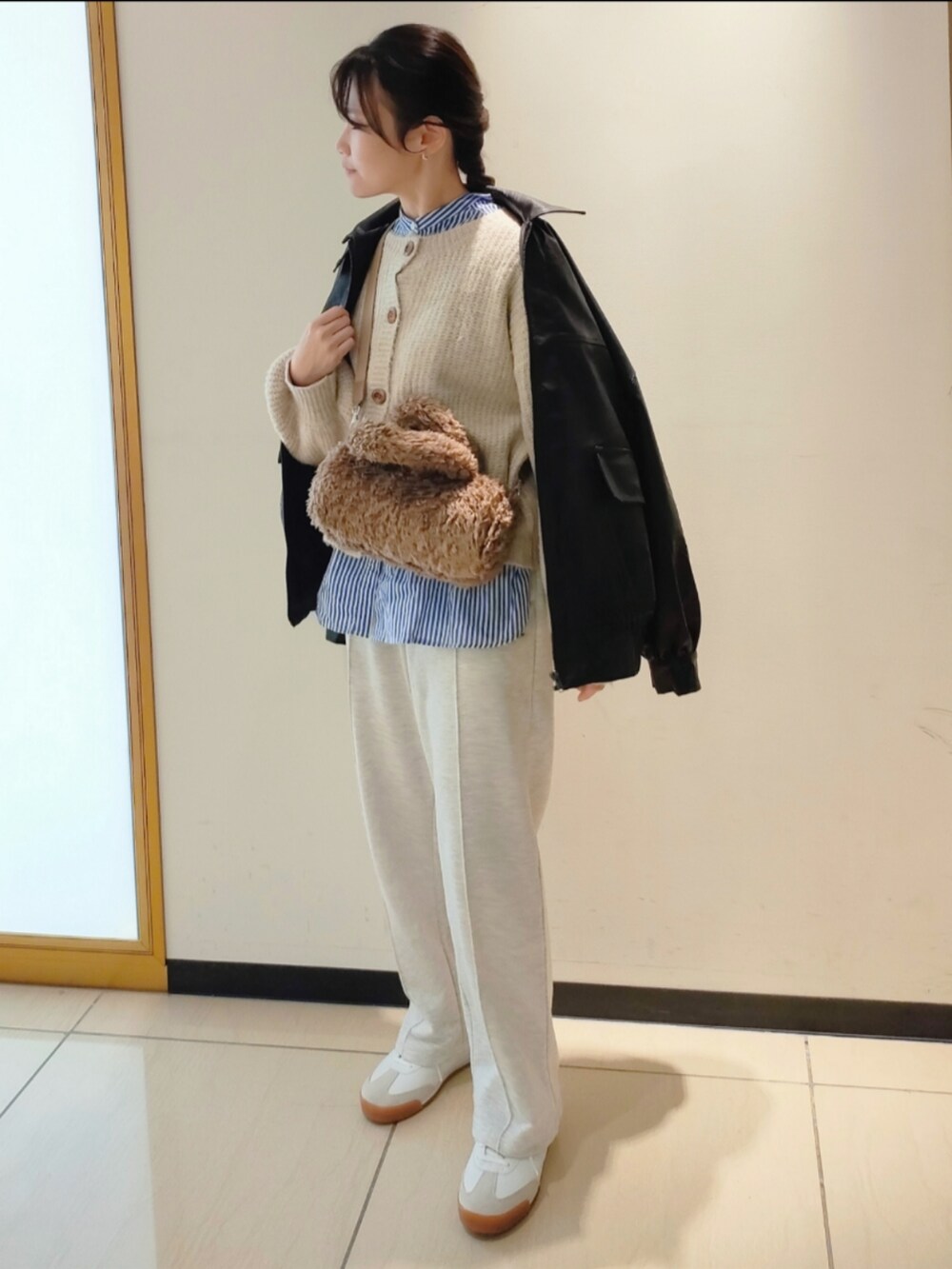 ベージュ系のスウェットパンツ、ブラック系のブルゾン、ホワイト系のカーディガン/ボレロを着用したレディースの秋コーディネートの3枚目の写真