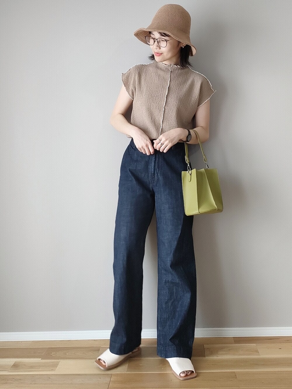 ブラウン系のTシャツ/カットソー、グリーン系のハンドバッグ、ホワイト系のサンダルを着用したレディースの春コーディネートの2枚目の写真