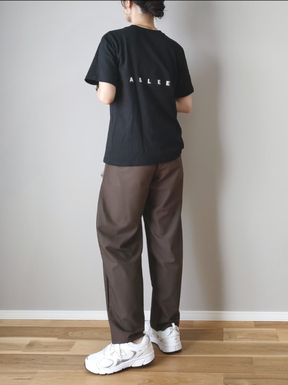 ブラウン系のスラックス、ブラック系のTシャツ/カットソー、ベージュ系のハンドバッグを着用したレディースの秋コーディネートの5枚目の写真