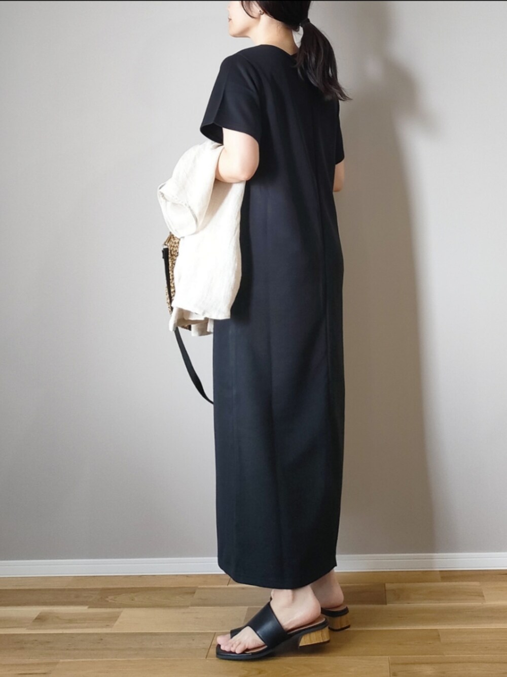 ブラック系のワンピース、ブラック系のサンダル、ブラック系のショルダーバッグを着用したレディースの夏コーディネートの3枚目の写真