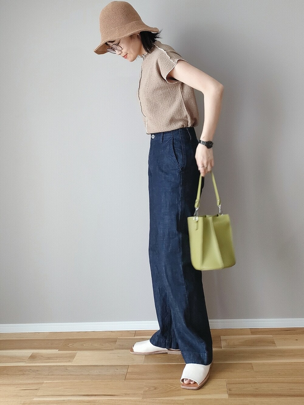 ブラウン系のTシャツ/カットソー、グリーン系のハンドバッグ、ホワイト系のサンダルを着用したレディースの春コーディネートの3枚目の写真