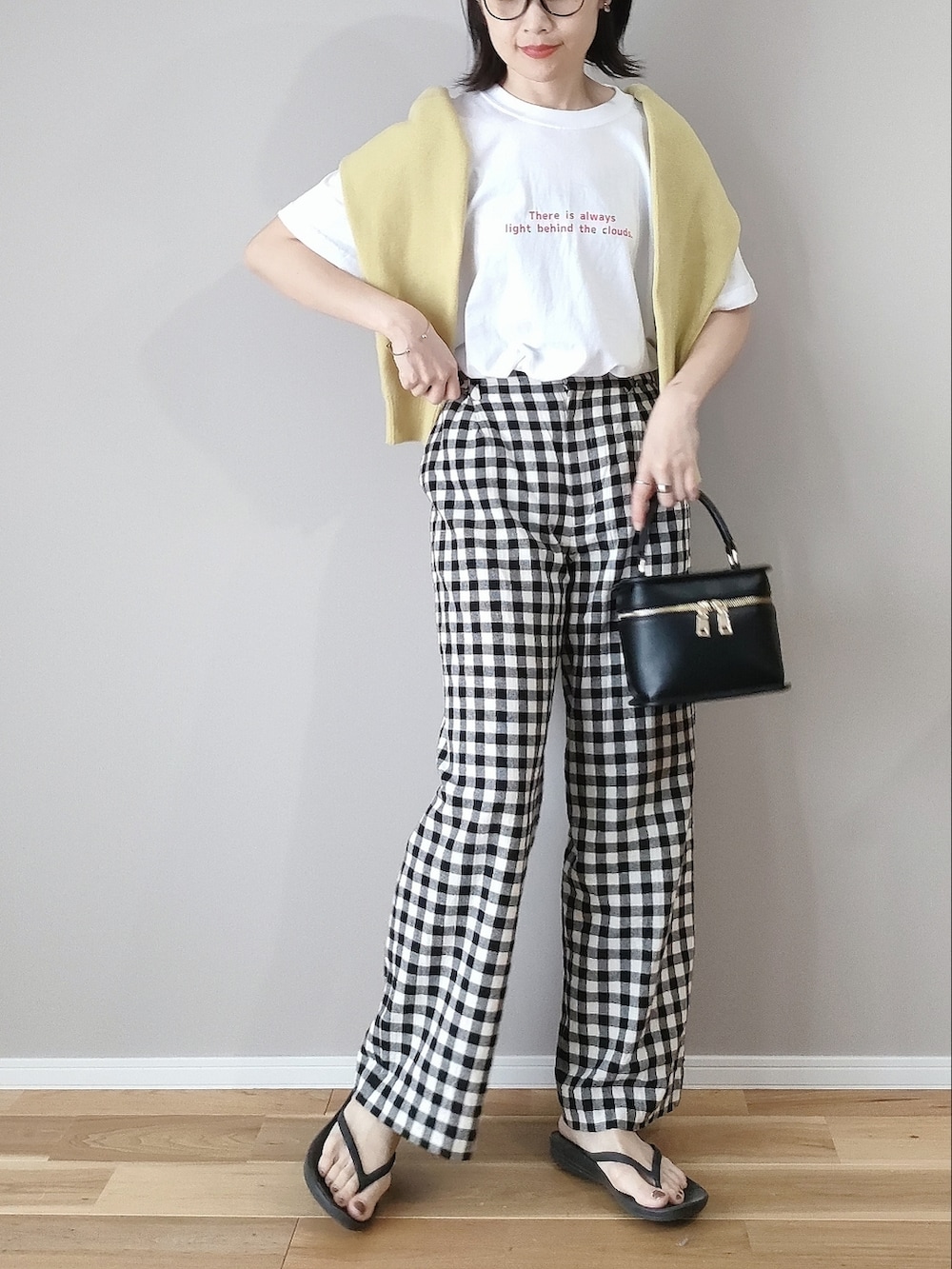 レッド系のTシャツ/カットソー、イエロー系のカーディガン/ボレロ、ブラック系のショルダーバッグを着用したレディースの春コーディネートの2枚目の写真