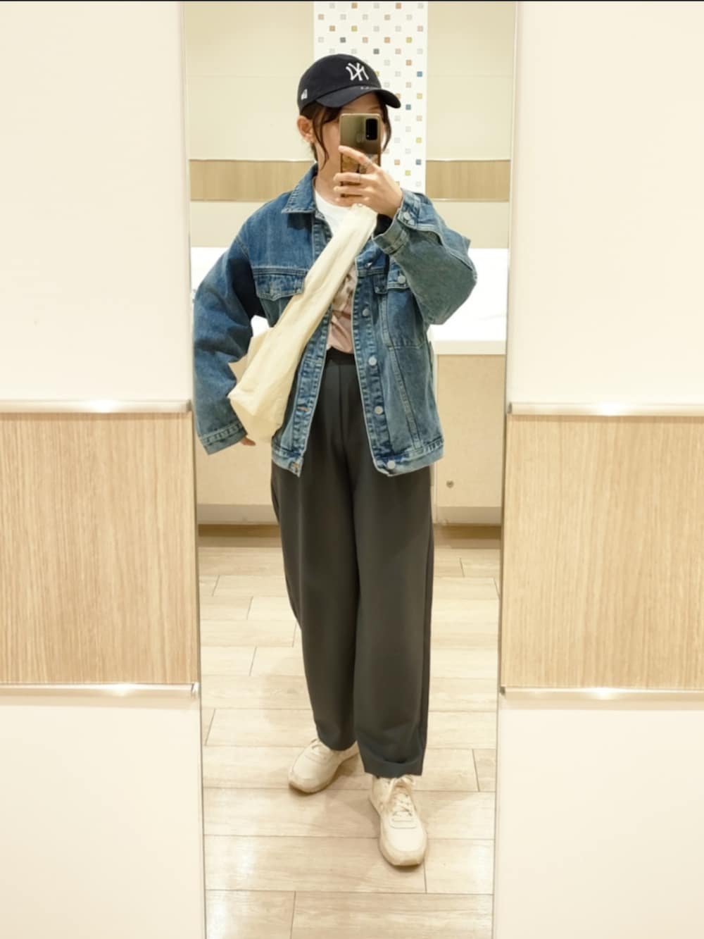 グレー系のスラックス、ブルー系のデニムジャケット、グリーン系のブルゾンを着用したレディースの春コーディネートの4枚目の写真