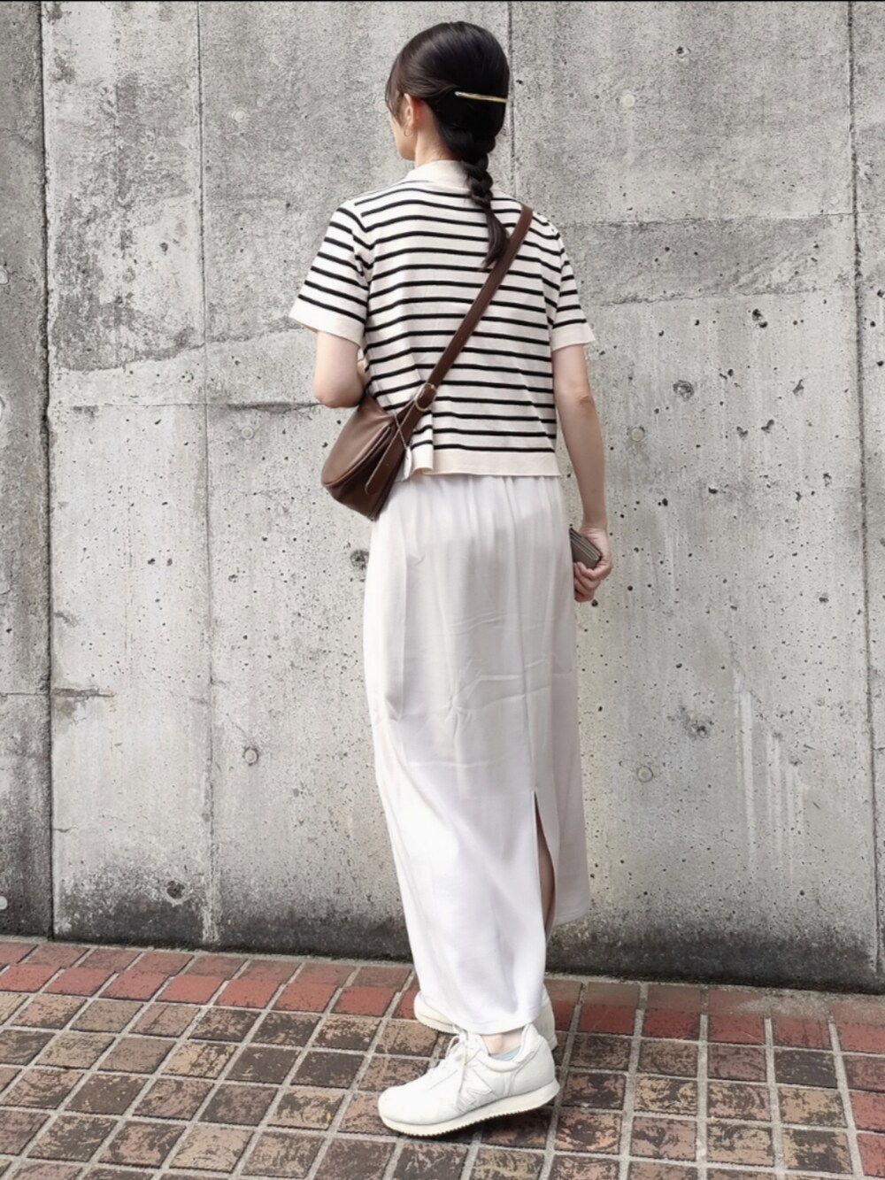 ブラウン系のショルダーバッグ、ホワイト系のスカート、ホワイト系のニット/セーターを着用したレディースの秋コーディネートの2枚目の写真