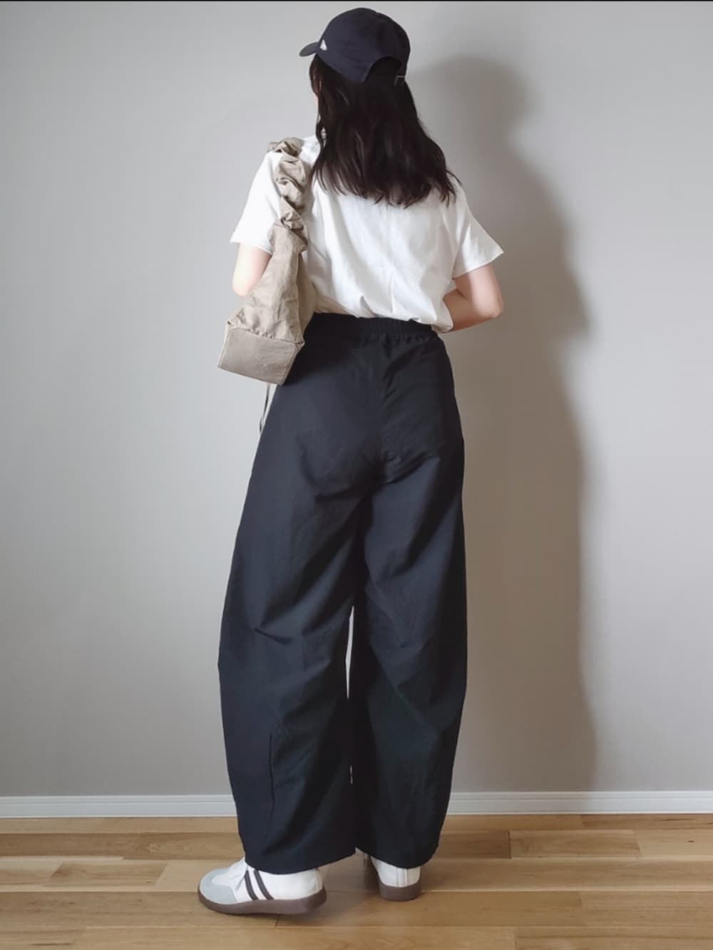 ブラック系のTシャツ/カットソー、ブラック系のカーゴパンツ、ベージュ系のハンドバッグを着用したレディースの春コーディネートの3枚目の写真