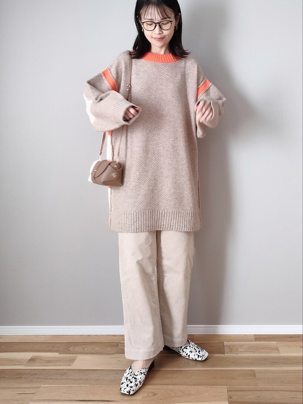 ベージュ系のニット/セーター、ホワイト系のサンダル、イエロー系のショルダーバッグを着用したレディースの冬コーディネートの3枚目の写真