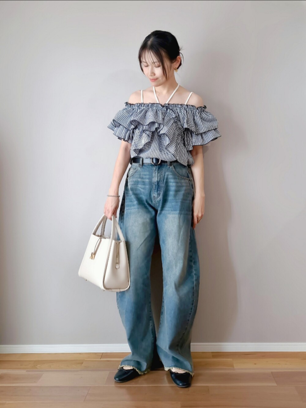 ブルー系のデニムパンツ、ホワイト系のトートバッグ、ブラック系のバレエシューズを着用したレディースの春コーディネートの2枚目の写真