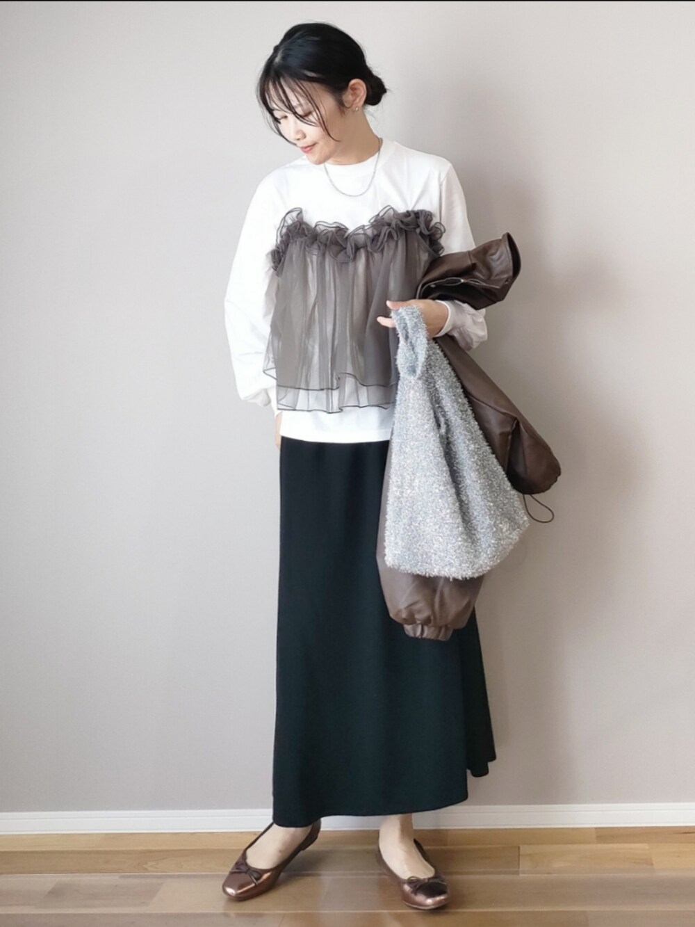 ブラウン系のブルゾン、ホワイト系のTシャツ/カットソー、ブラック系のスカートを着用したレディースの秋コーディネートの3枚目の写真