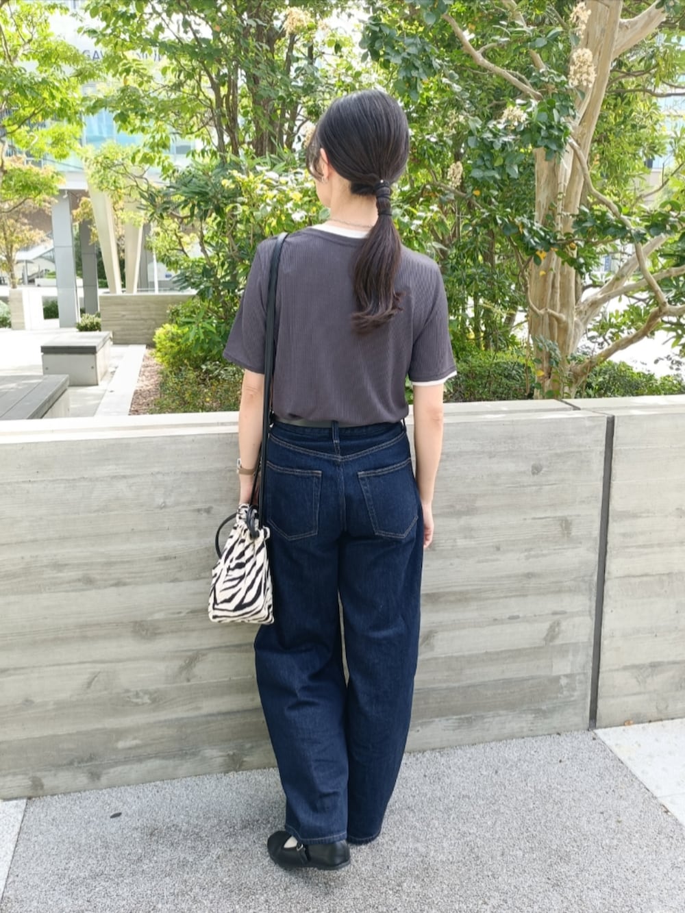 ブルー系のデニムパンツ、ブラック系のバレエシューズ、グレー系のTシャツ/カットソーを着用したレディースの秋コーディネートの3枚目の写真