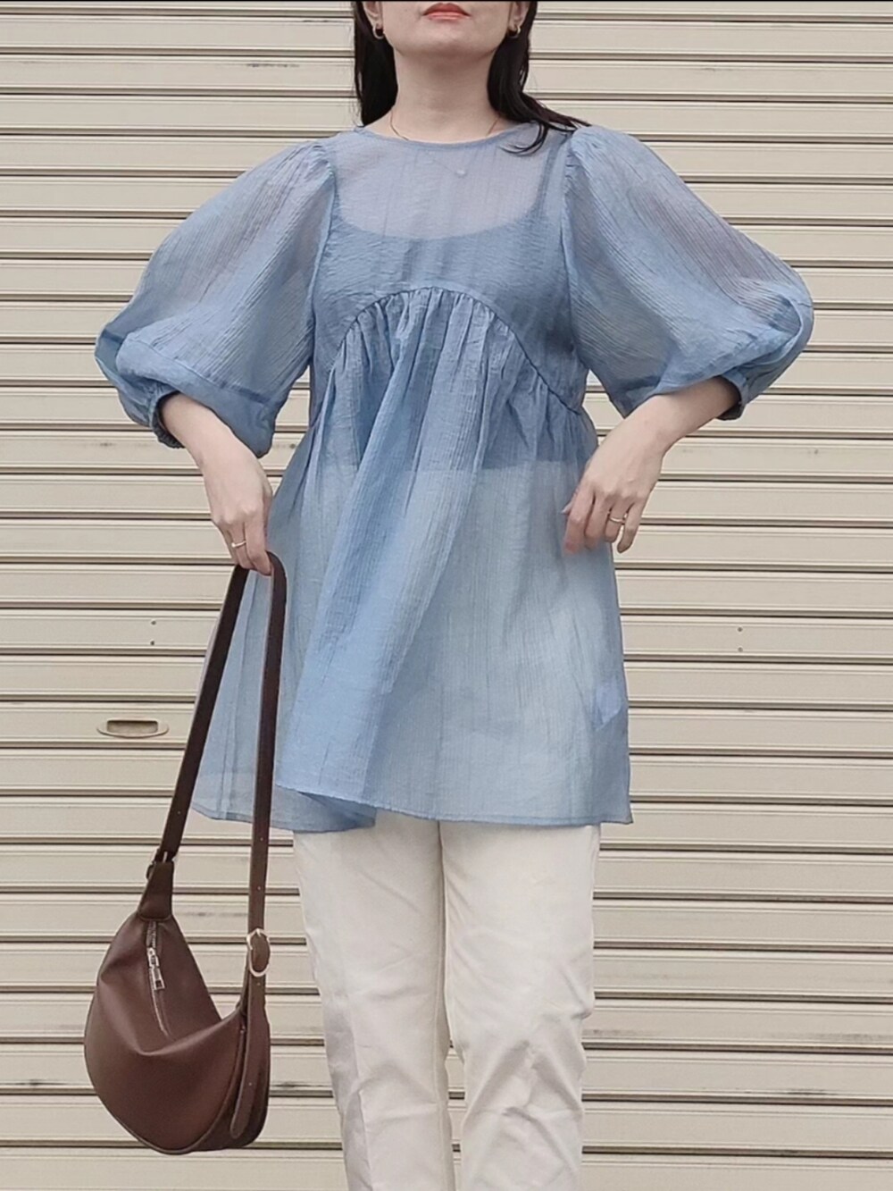 ブルー系のシャツ/ブラウス、ブラウン系のショルダーバッグ、ブラック系のバレエシューズを着用したレディースの春コーディネートの2枚目の写真