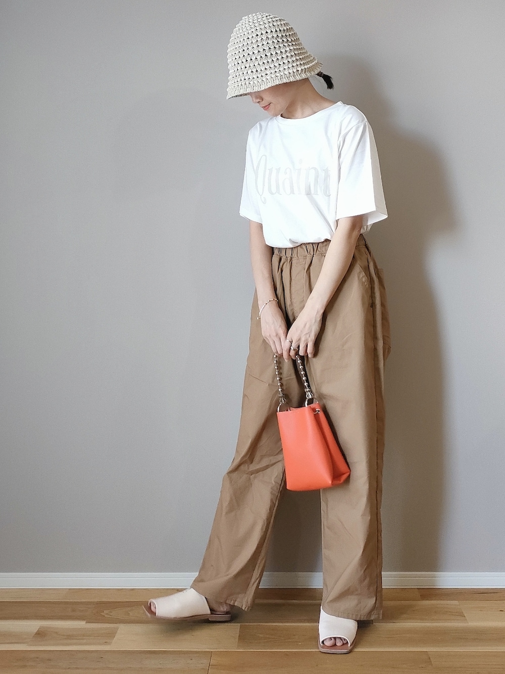 ホワイト系のTシャツ/カットソー、オレンジ系のショルダーバッグ、ベージュ系のその他パンツを着用したレディースの夏コーディネートの2枚目の写真