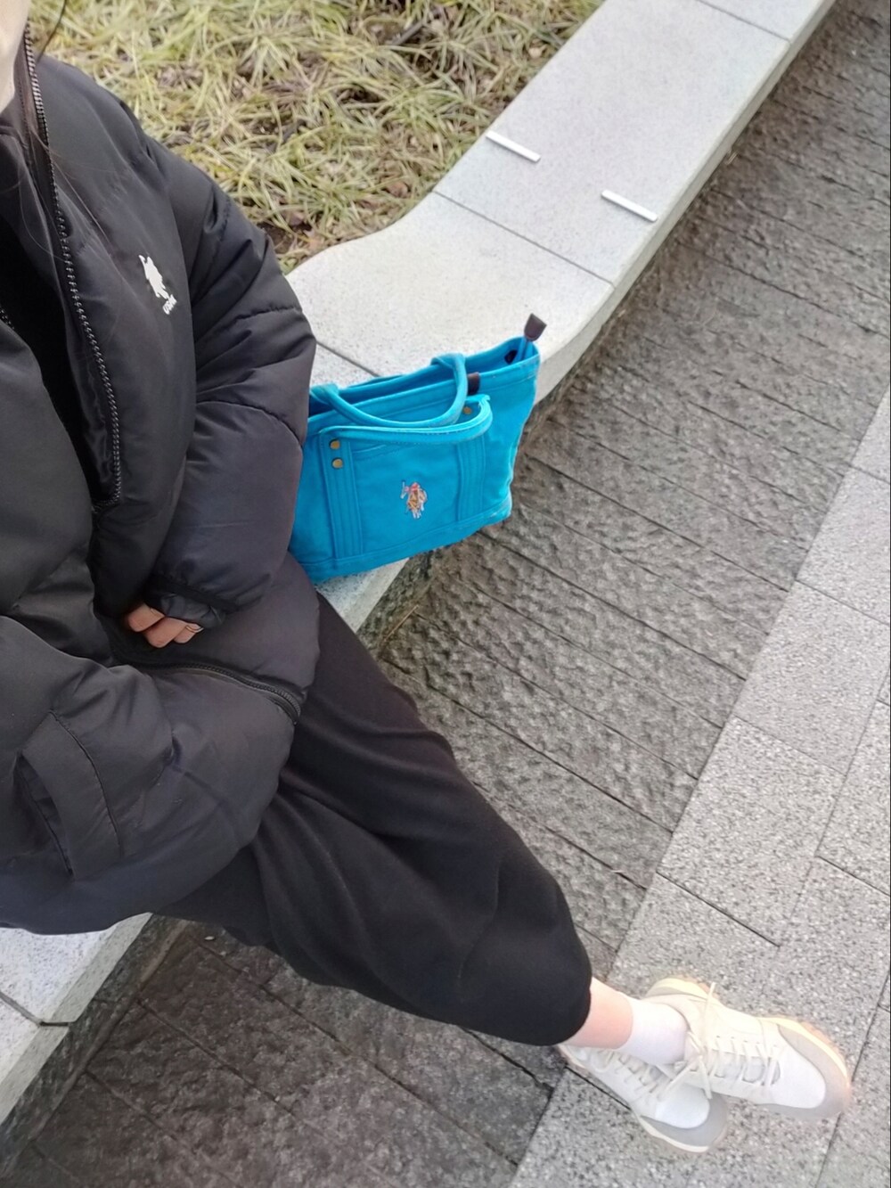 ブルー系のトートバッグ、ブラック系のワンピース、ベージュ系のスニーカーを着用したレディースの冬コーディネートの2枚目の写真