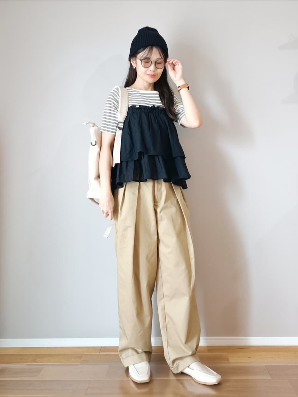 ブラック系のスカート、ホワイト系のTシャツ/カットソー、ベージュ系のチノパンツを着用したレディースの春コーディネートの4枚目の写真