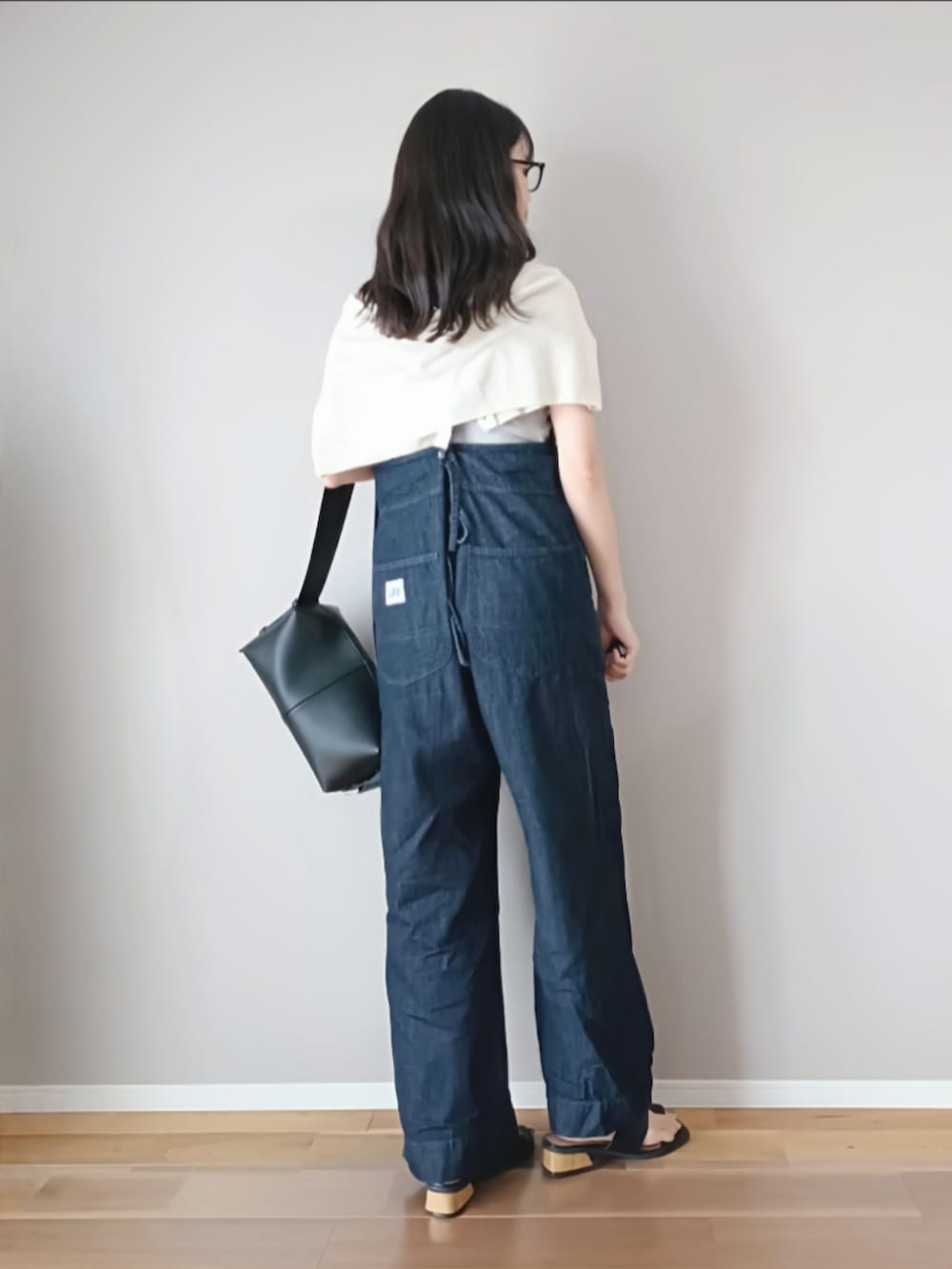 ブラック系のショルダーバッグ、ブラック系のサンダル、グレー系のタンクトップを着用したレディースの夏コーディネートの3枚目の写真