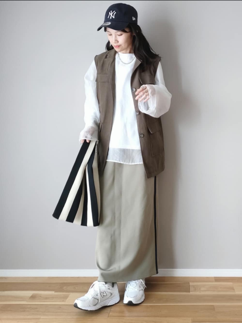 ホワイト系のシャツ/ブラウス、グリーン系のベスト、ブルー系のスカートを着用したレディースの秋コーディネートの3枚目の写真