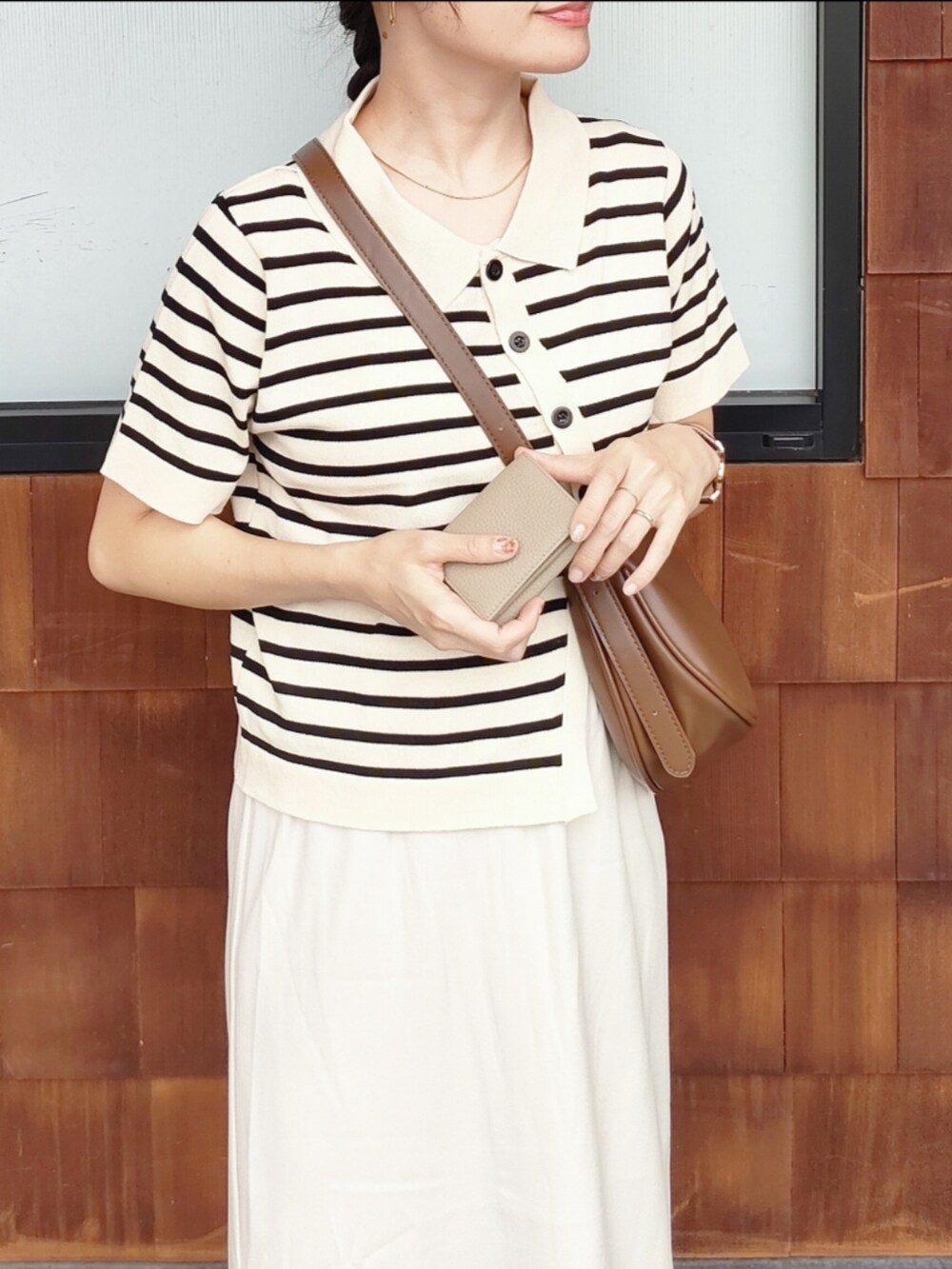 ブラウン系のショルダーバッグ、ホワイト系のスカート、ホワイト系のニット/セーターを着用したレディースの秋コーディネートの3枚目の写真