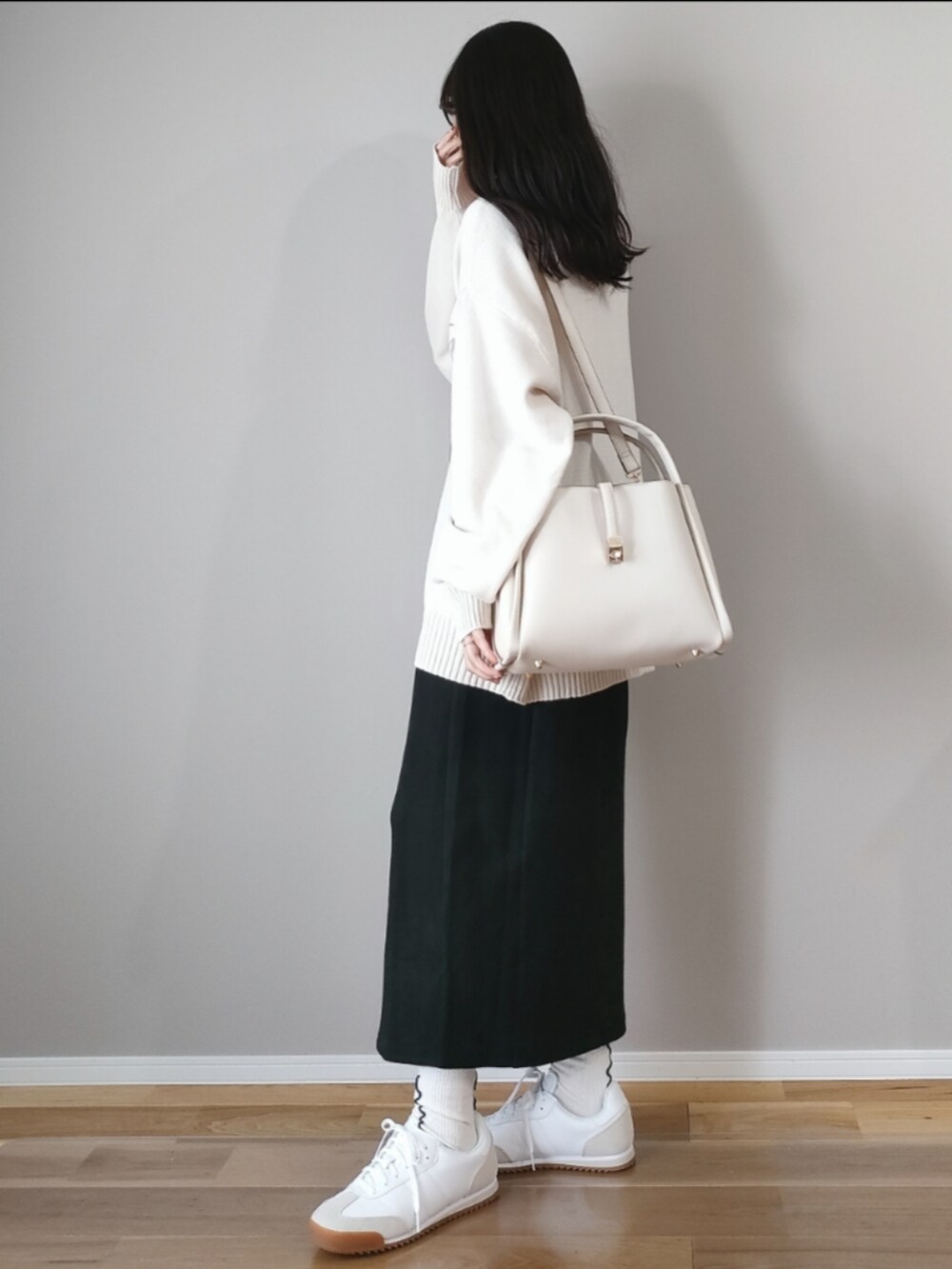 ホワイト系のトートバッグ、ブラック系のスカート、ホワイト系のニット/セーターを着用したレディースの秋コーディネートの3枚目の写真