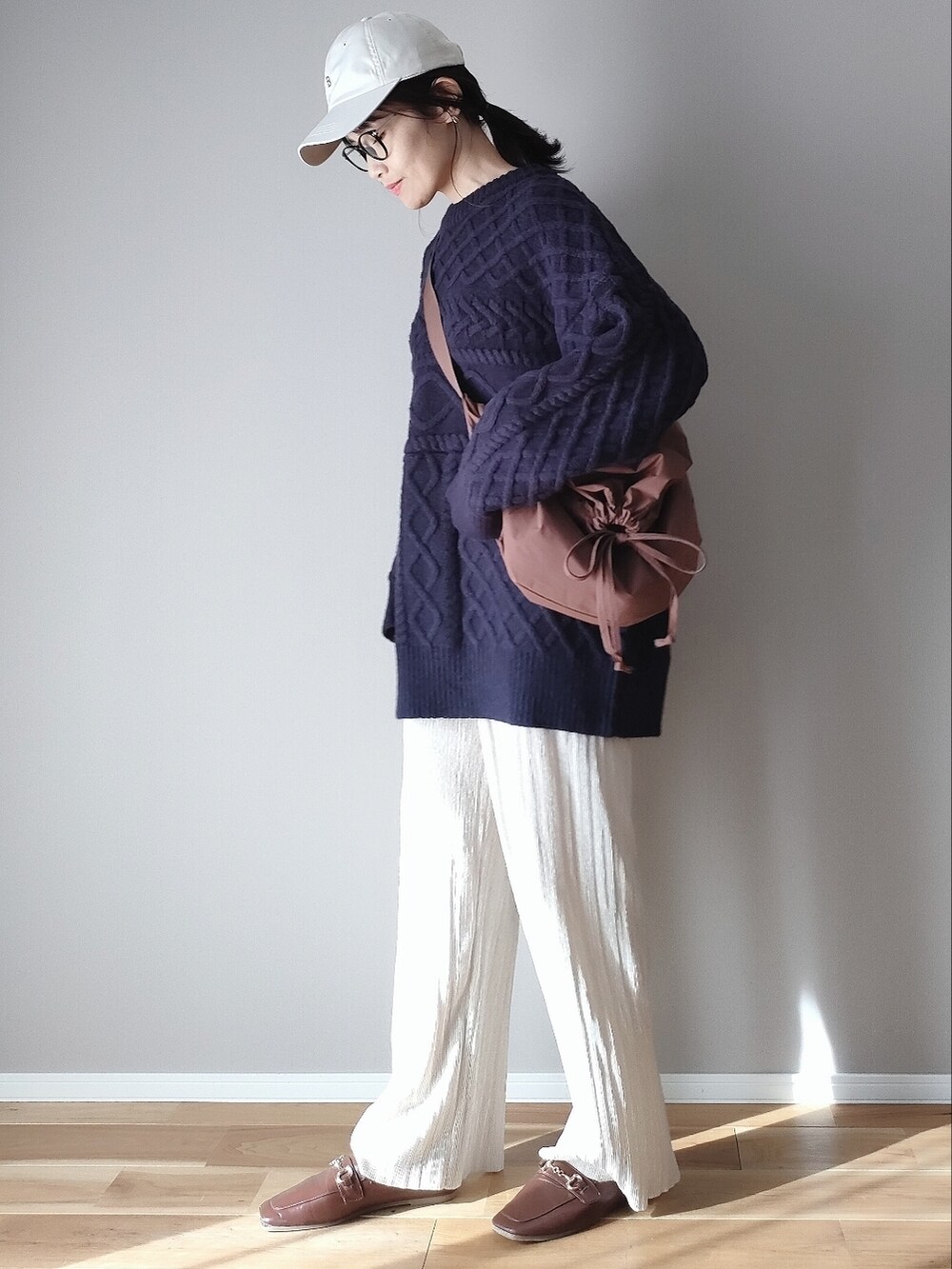 ブルー系のニット/セーター、ブラウン系のショルダーバッグ、ブラウン系のサンダルを着用したレディースの秋コーディネートの2枚目の写真