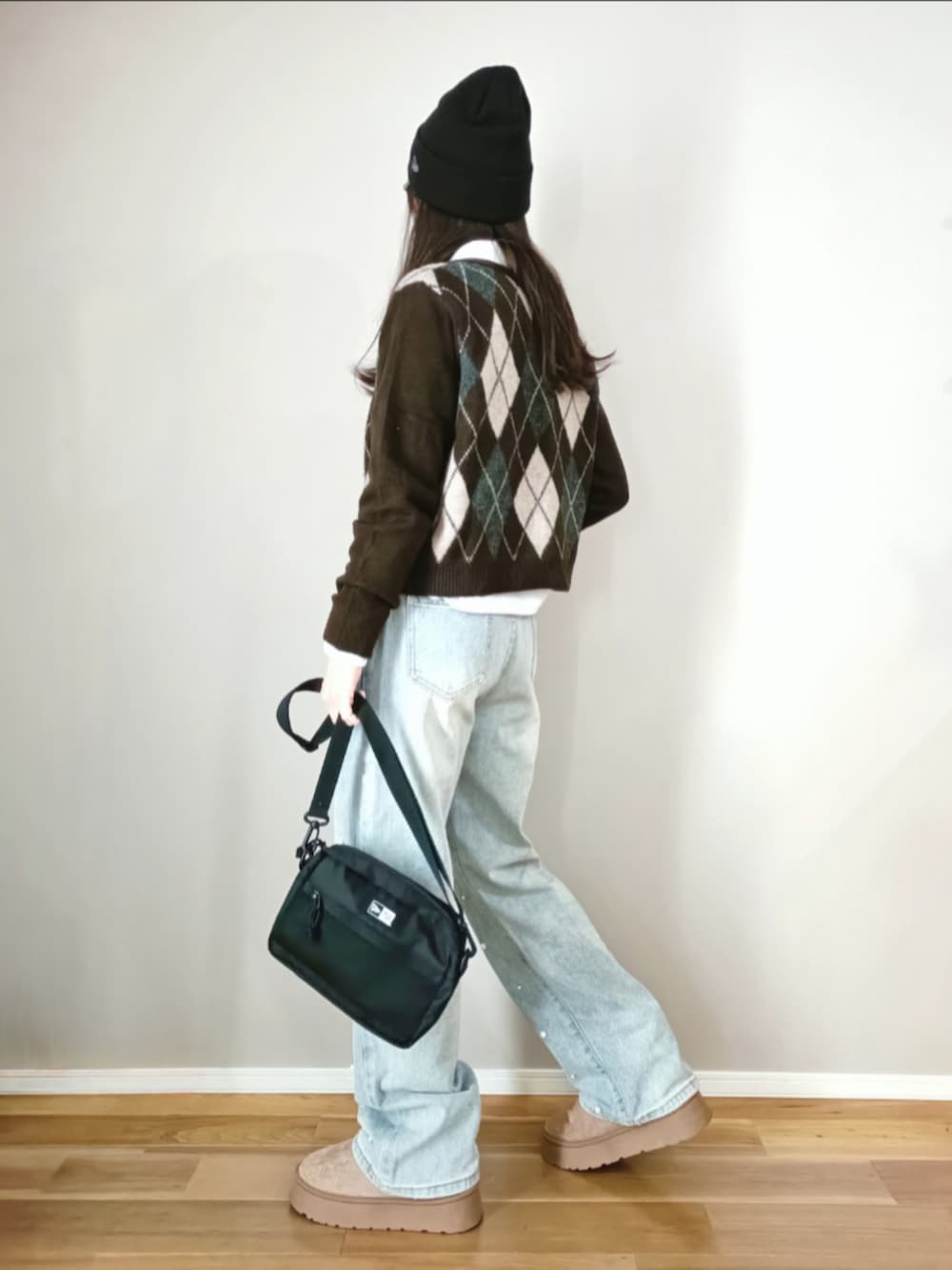 ブルー系のデニムパンツ、ブラック系のショルダーバッグ、ブラウン系のカーディガン/ボレロを着用したレディースの冬コーディネートの5枚目の写真