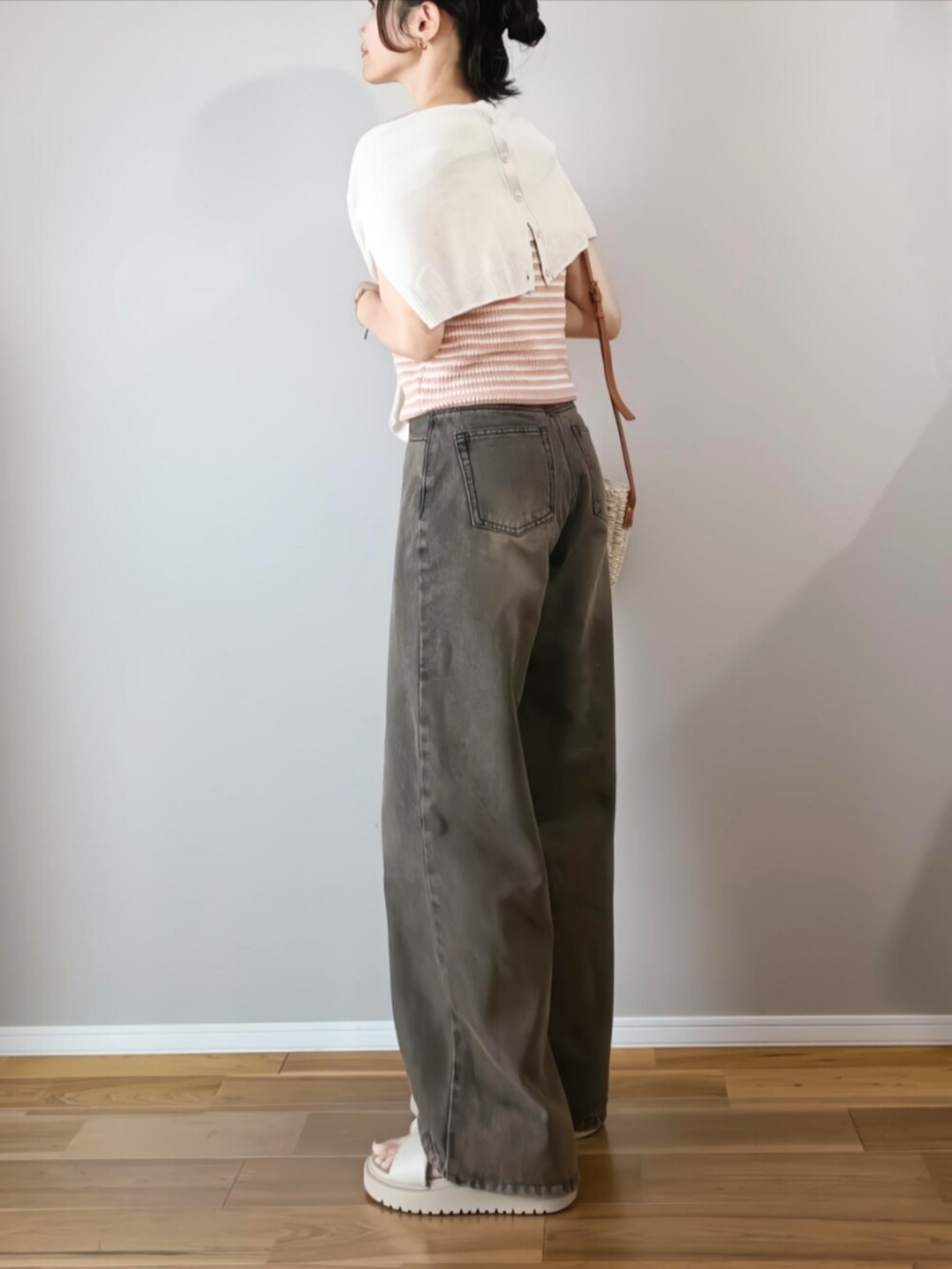 ブラック系のデニムパンツ、ピンク系のタンクトップ、ブラウン系のかごバッグを着用したレディースの夏コーディネートの3枚目の写真