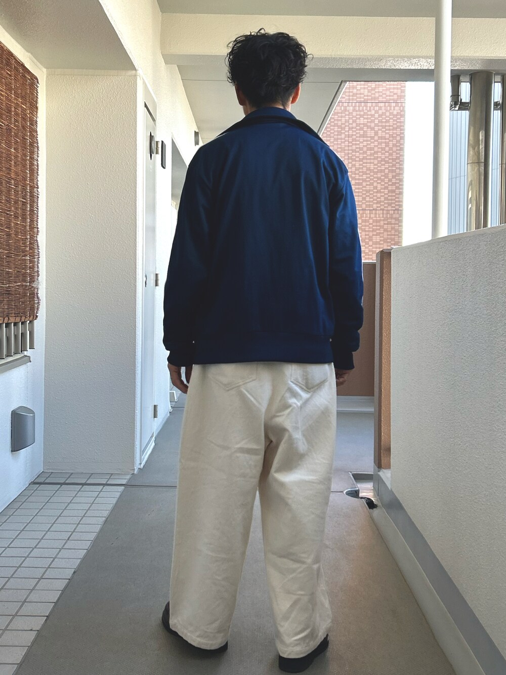 ブルー系のブルゾン、ホワイト系のシャツ/ブラウス、ホワイト系のパンツを着用したメンズの秋コーディネートの3枚目の写真