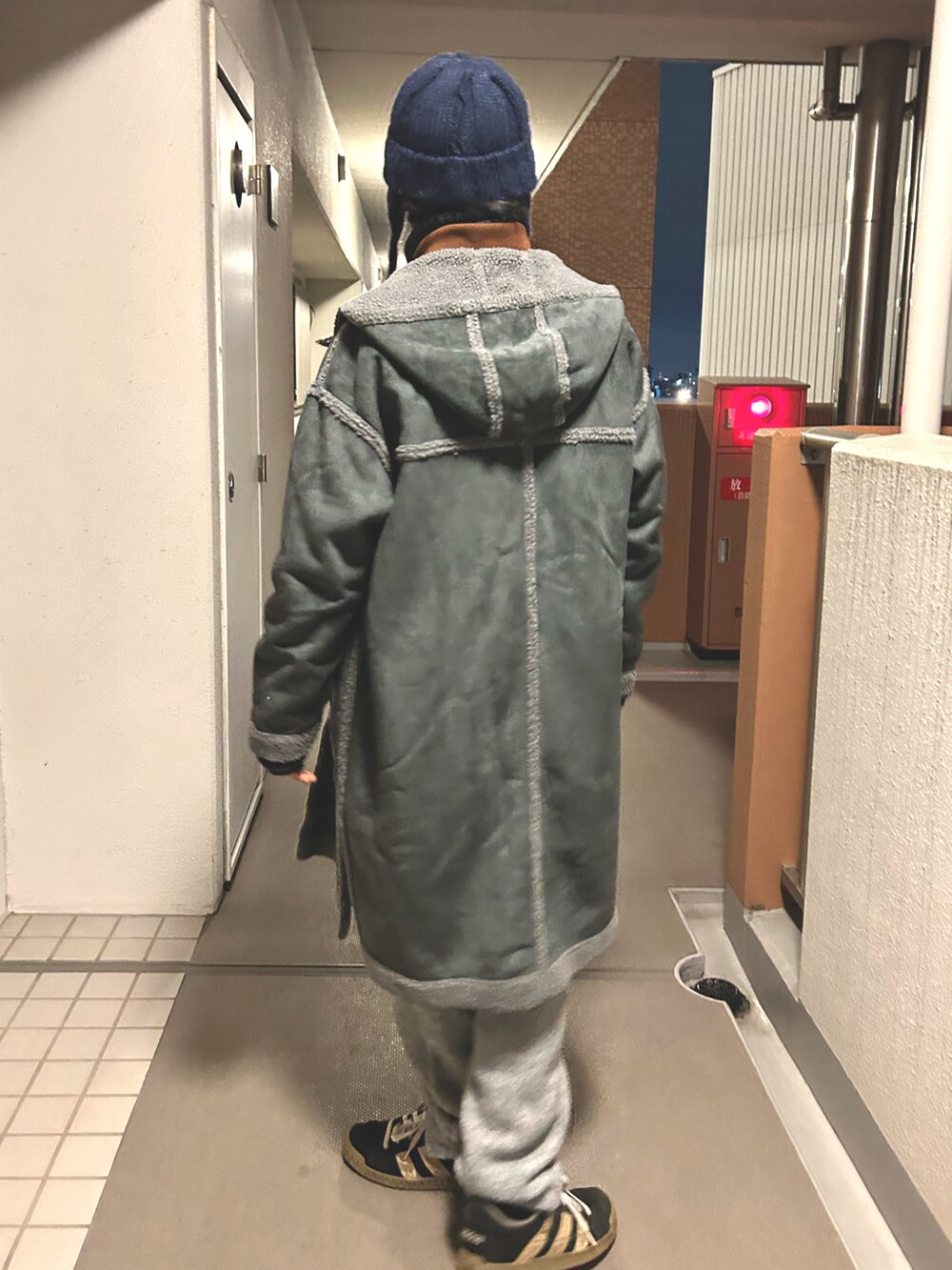 ベージュ系のベスト、グレー系のステンカラーコート、グレー系のその他パンツを着用したメンズの冬コーディネートの3枚目の写真