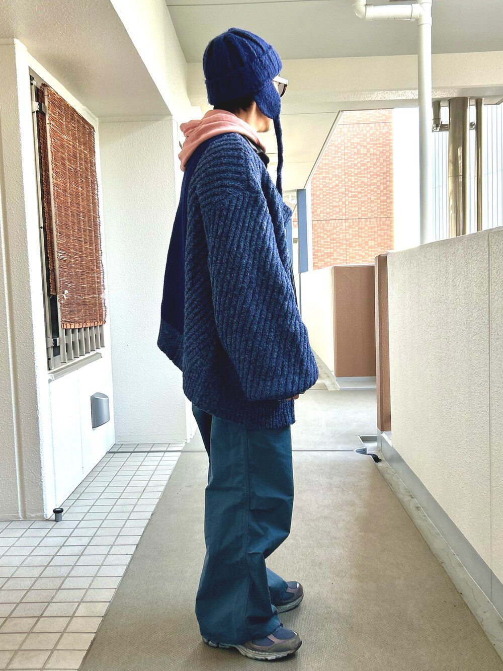 「真冬のあったかスタイル、冬コーデ、レイヤードスタイル、カーディガン、レザージャケット、ワイドパンツ、サングラス、大人カジュアル、ブルー、ニューバランス」｜「UNE MANSIONのフライトキャップ/ニット耳あて帽子（ニットキャップ/ビーニー、ブルー系）」を使った、yosukeさん（メンズ・168cm）の冬コーディネートの3枚目の写真