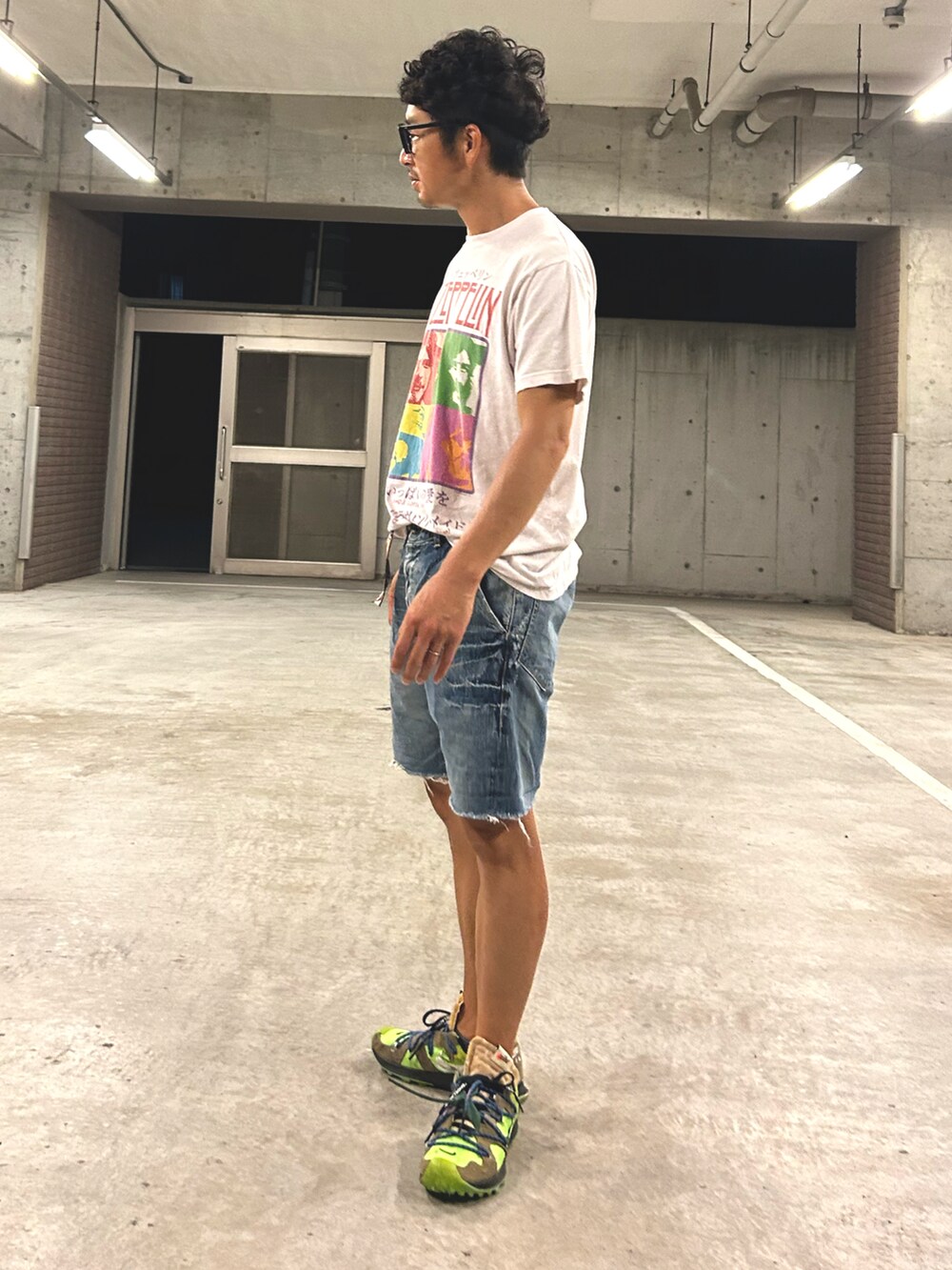 ブルー系のデニムパンツ、ホワイト系のTシャツ/カットソー、グリーン系のスニーカーを着用したメンズの秋コーディネートの2枚目の写真