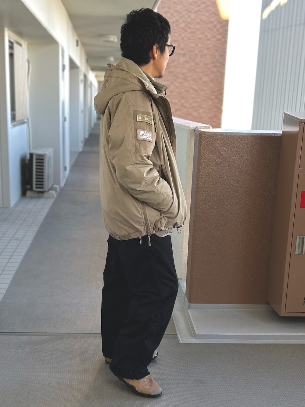 ベージュ系のブルゾン、ベージュ系のダウンジャケット/コート、ブラック系のパンツを着用したメンズの冬コーディネートの2枚目の写真