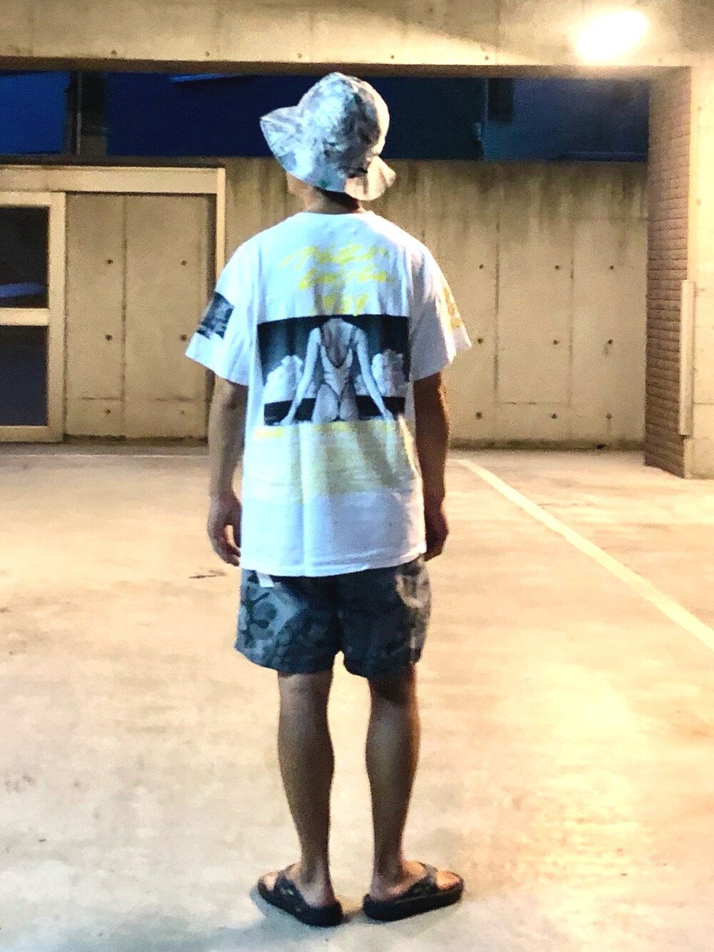 ホワイト系のTシャツ/カットソー、グレー系のその他パンツ、ブラック系のサンダルを着用したメンズの夏コーディネートの4枚目の写真