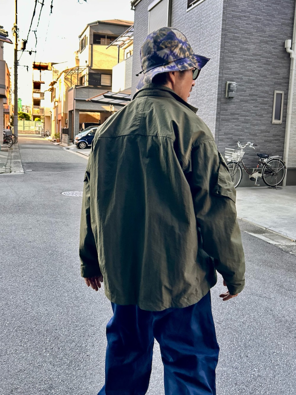 「春コーデ、オールインワン、つなぎ、ジャンプスーツ、BBQ、アウトドアスタイル、ミリタリー、タイダイ柄、バケットハット、ゆるコーデ」｜「CMF OUTDOOR GARMENTのCOMFY OUTDOOR GARMENT/コンフィ― アウトドア ガーメンツ SLING SHOT/スリングショット（ブルゾン、グリーン系）」を使った、yosukeさん（メンズ・168cm）の春コーディネートの3枚目の写真