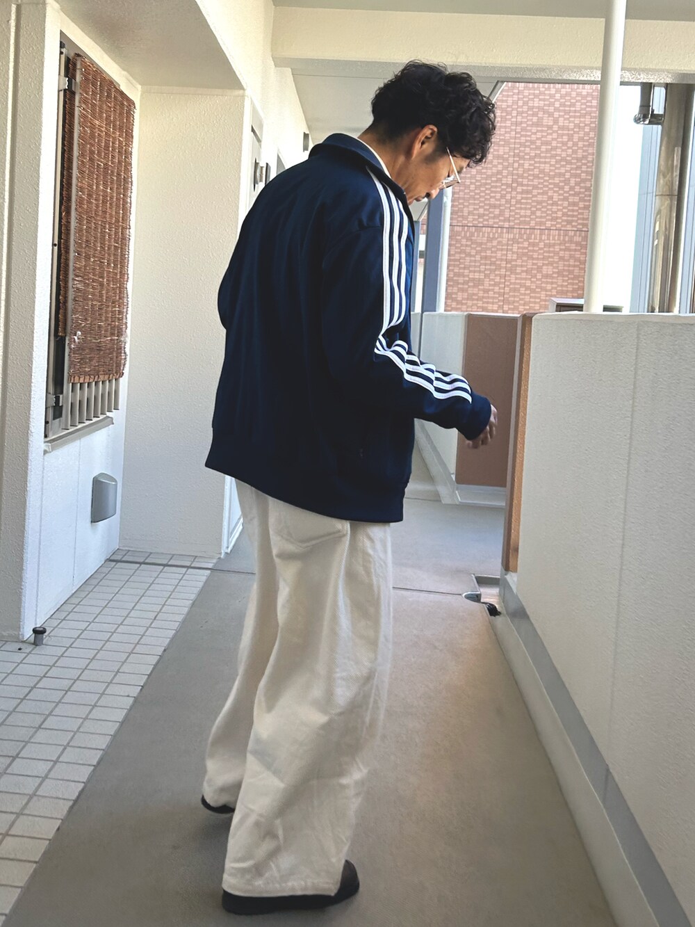 ブルー系のブルゾン、ホワイト系のシャツ/ブラウス、ホワイト系のパンツを着用したメンズの秋コーディネートの2枚目の写真