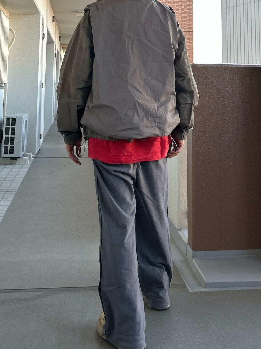 グレー系のマウンテンパーカー、グレー系のベスト、グレー系のその他パンツを着用したメンズの冬コーディネートの3枚目の写真