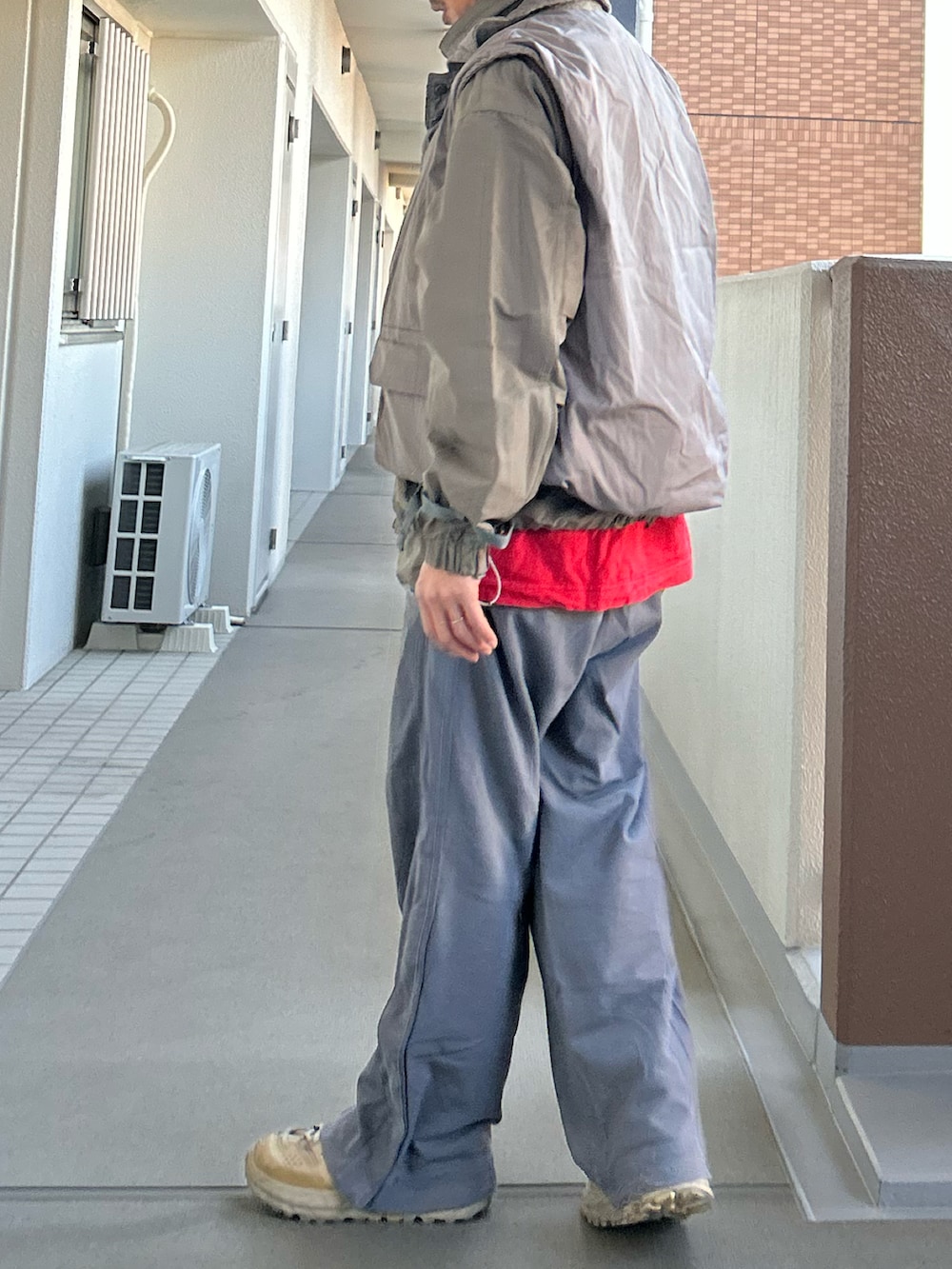 グレー系のマウンテンパーカー、グレー系のベスト、グレー系のその他パンツを着用したメンズの冬コーディネートの2枚目の写真