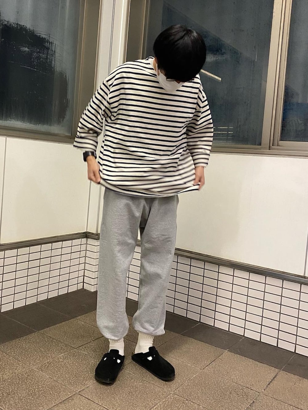 グレー系のスウェットパンツ、ブラック系のサンダル、ブラック系のTシャツ/カットソーを着用したメンズの春コーディネートの3枚目の写真